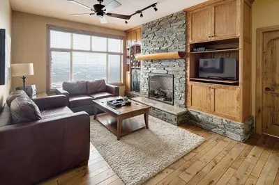 a living room with a couch and a fireplace at Luxury Aspens 2 Bdrm Condo with Best Views in Big White