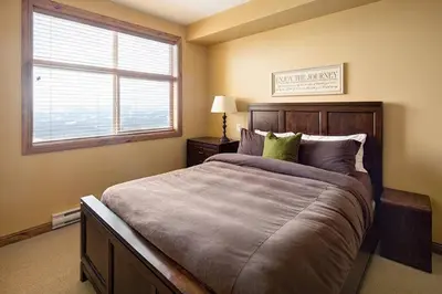 a bedroom with a large bed and a window at Luxury Aspens 2 Bdrm Condo with Best Views in Big White