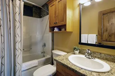 a bathroom with a sink and a toilet and a shower at Luxury Aspens 2 Bdrm Condo with Best Views in Big White