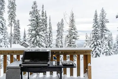 a laptop on a table on a deck in the snow at Eagle Ridge Pet-Friendly Chalet in Big White
