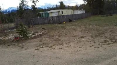 a dirt yard with a fence and a fence at Right Choice Home Valemount in Valemount