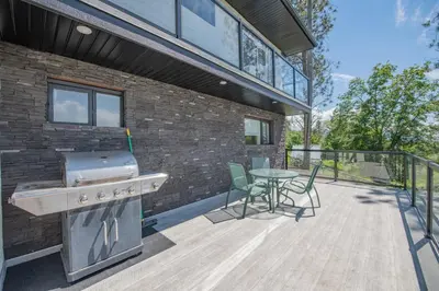 a patio with a grill and a table and chairs at Lakeviews, big yard/deck, minutes to Silver Star/Golf/Wineries. in Vernon
