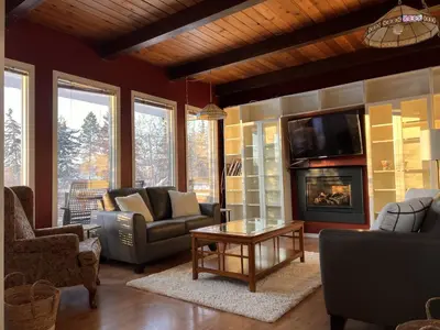 a living room with couches and a tv and a fireplace at Whitehorse Home on the River in Whitehorse
