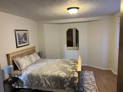 a bedroom with a bed and a mirror in it at Whitehorse Home on the River in Whitehorse