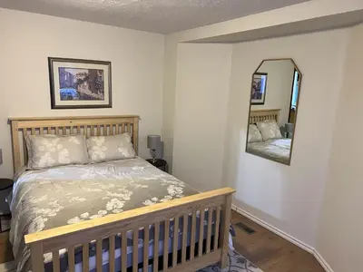 a bedroom with a bed and a mirror at Whitehorse Home on the River in Whitehorse