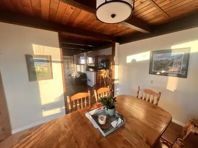 a dining room with a wooden table and chairs at Whitehorse Home on the River in Whitehorse