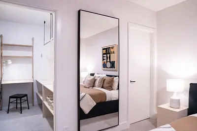 a mirror in a bedroom with a bed at Snow & Swing Getaway - Three Bedrooms with Hot Tub (Stay Revy) in Revelstoke