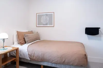 a small bedroom with a bed and a table at Snow & Swing Getaway - Three Bedrooms with Hot Tub (Stay Revy) in Revelstoke