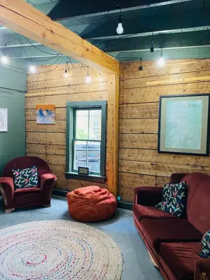 a living room with two chairs and a rug at Dancing Bear Inn in Nelson