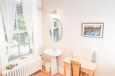 a bathroom with a sink and a table and a mirror at Dancing Bear Inn in Nelson