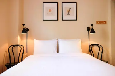 a bedroom with a large white bed with two lamps at Dancing Bear Inn in Nelson