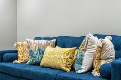 a blue couch with a bunch of pillows on it at Newly renovated 2 bedroom basement suite in Calgary