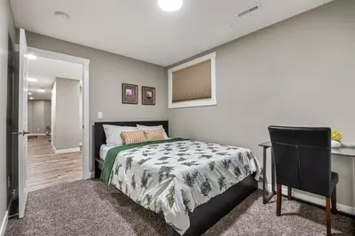 a bedroom with a bed and a desk and a chair at Newly renovated 2 bedroom basement suite in Calgary