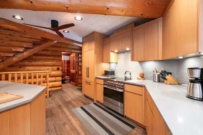 a kitchen with wooden cabinets and a stove top oven at Snowridge Chalet by Outpost Whistler in Whistler