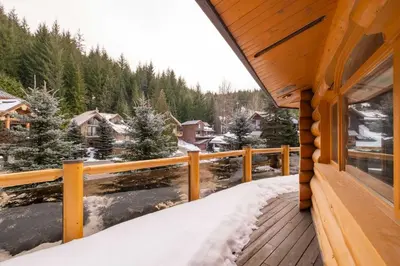 a view from the deck of a cabin in the snow at Snowridge Chalet by Outpost Whistler in Whistler