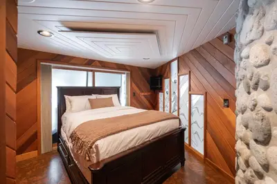 a bedroom with a bed in a room with wooden walls at Snowridge Chalet by Outpost Whistler in Whistler