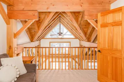 a living room with a couch and a large window at Alpine Timber Luxury Chalet w/Hot Tub in Big White