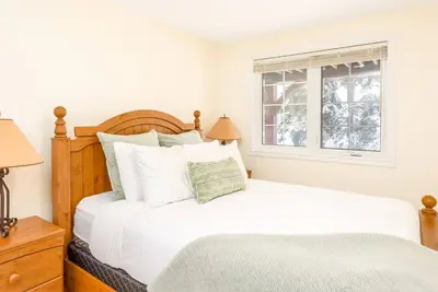 a bedroom with a bed and a window at Alpine Timber Luxury Chalet w/Hot Tub in Big White