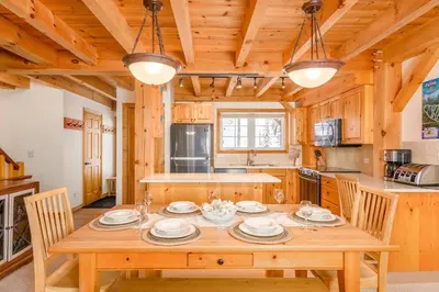a dining room with a wooden table in a kitchen at Alpine Timber Luxury Chalet w/Hot Tub in Big White