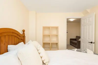 a bedroom with a white bed and a couch at Alpine Timber Luxury Chalet w/Hot Tub in Big White
