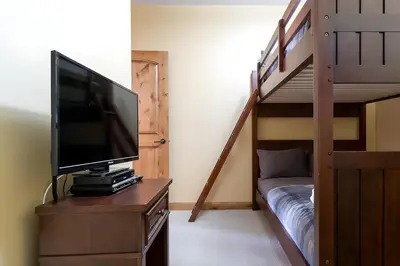 a room with a television and a bunk bed at The Aspens 5 w/ Hot Tub in Big White