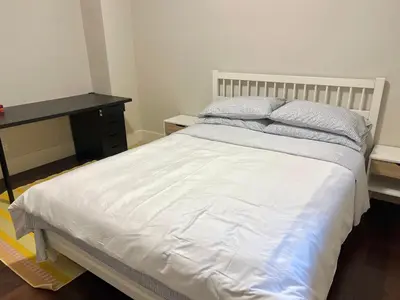 a bedroom with a white bed and a desk at Cozy and Private Suite in Richmond in Richmond