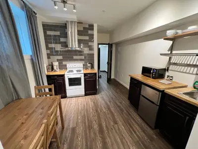 a kitchen with a sink and a stove top oven at Dt 1Bed 1bath Cozy Suite 8 Min Walk To Arena in Edmonton
