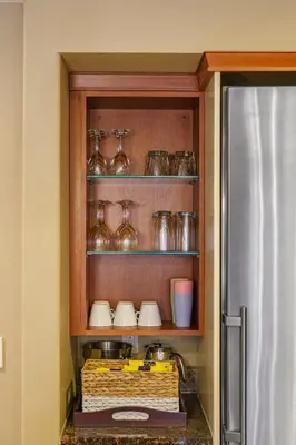 a kitchen with a shelf with glasses and a refrigerator at Adventurer's Escape~ Mountain Luxury Resort in Canmore