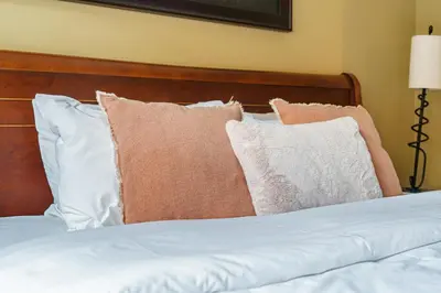 a pile of pillows sitting on top of a bed at Adventurer's Escape~ Mountain Luxury Resort in Canmore