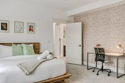 a bedroom with a bed and a desk with a chair at Emerald Bay Luxury Retreat with Hot Tub in Calgary
