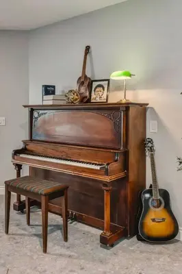 a piano and a guitar in a room with a lamp at Emerald Bay Luxury Retreat with Hot Tub in Calgary