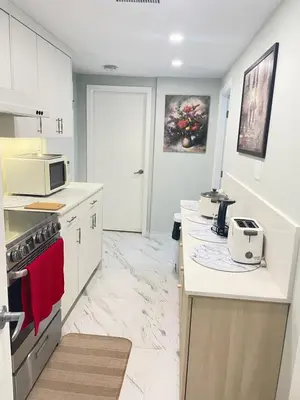 a kitchen with white cabinets and a white counter top at Arbutus violet room in Vancouver