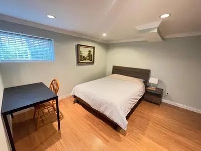 a bedroom with a bed and a table and a desk at Arbutus violet room in Vancouver