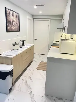 a kitchen with white marble floors and a sink at Arbutus violet room in Vancouver