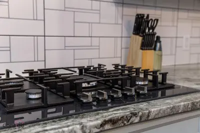 a black stove top sitting on top of a counter at The Azure, Near DT & University, TWO King Beds! in Edmonton
