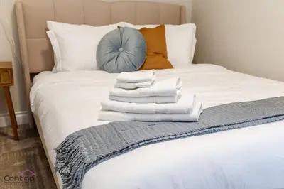 a pile of towels sitting on top of a bed at The Azure, Near DT & University, TWO King Beds! in Edmonton