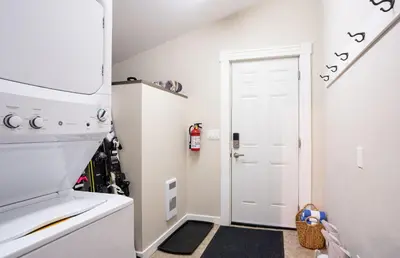 a small kitchen with a white stove and a white door at Downtown Home Private Hot Tub Walkable Location in Revelstoke