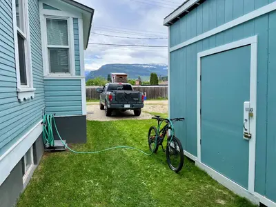 a bike is parked next to a house with a truck at Downtown Home Private Hot Tub Walkable Location in Revelstoke