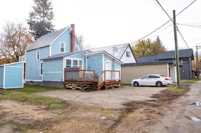 a blue house with a car parked in front of it at Downtown Home Private Hot Tub Walkable Location in Revelstoke