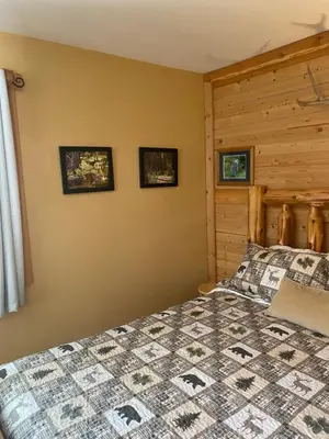a bedroom with a bed and a wooden wall at 1868 Noble Cottage in Clearwater