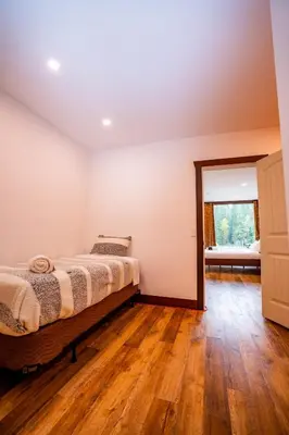 a bedroom with a bed and a wooden floor at River Safari Lodge in Blue River