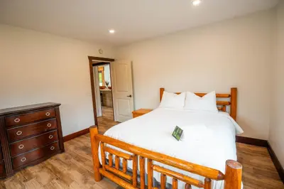 a bedroom with a large bed and a wooden dresser at River Safari Lodge in Blue River
