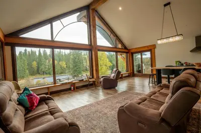 a living room with couches and a large window at River Safari Lodge in Blue River