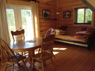 a dining room with a table and chairs in a cabin at Cabins Over Crag Lake in Carcross