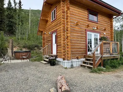 a log cabin with a porch and a door at Cabins Over Crag Lake in Carcross