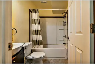 a bathroom with a tub and a toilet and a sink at Basement Room in Calgary