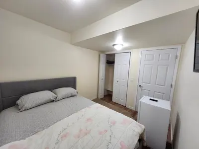 a bedroom with a bed and a white door at Basement Room in Calgary