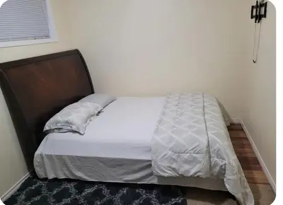 a bedroom with a bed with a wooden headboard at Basement Room in Calgary