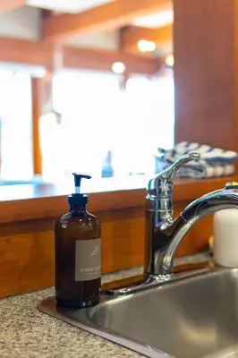 a bottle of soap sitting on a kitchen sink at Waterfront Condo in Ucluelet in Ucluelet