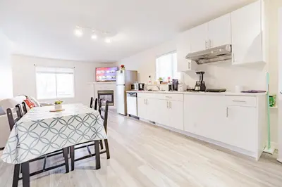 a kitchen and dining room with a table and a table and chairs at Walkout Basement Suite, 2 BDR 4BD, Bright and Spacious in Calgary